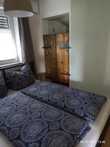 um quarto com uma cama e uma porta de madeira em Ferienwohnung Abendsonne em Horgenzell