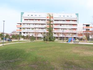 een groot gebouw met een park ervoor bij Nest Eco Guesthouse in Udine