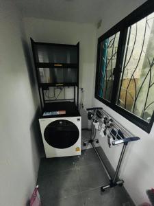 une petite cuisine avec un four micro-ondes et une fenêtre dans l'établissement KITJA MY HOME, à Hat Yai
