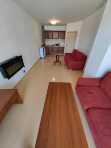 ein Wohnzimmer mit einem roten Sofa und einem Tisch in der Unterkunft Gondola Paradise - 50m Away, 250mbps Wi-fi in Bansko