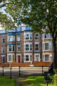 a large brick building with white windows and a bench at 23 Trafalgar Square with hot tub and cinema in Scarborough