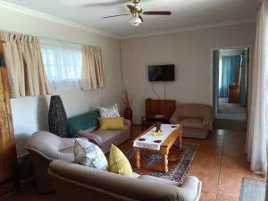 a living room with couches and a coffee table at Charming Randburg Accommodation near the Olivedale Clinic in Sandton