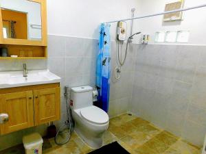 a bathroom with a shower and a toilet and a sink at Swiss Bonihouse Koh Yao Yai in Ban Phlu Nai