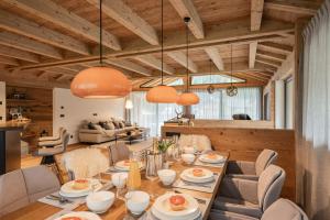 Vista Chalets Sexten في سيستو: غرفة طعام مع طاولة وكراسي طويلة