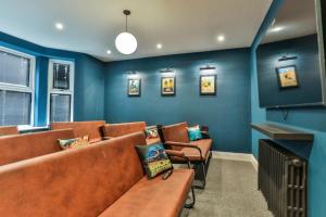 una sala de espera con sofás marrones y paredes azules en 23 Trafalgar Square with hot tub and cinema, en Scarborough