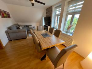 un salon avec une table et des chaises en bois dans l'établissement FeWo Schlossblick #Innenstadt #Garten #Netflix von Harztraveler, à Wernigerode