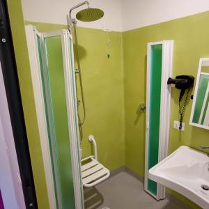 La salle de bains est pourvue d'une douche et d'un lavabo. dans l'établissement Bohoostel, à Bologne
