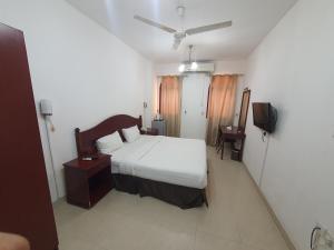 a bedroom with a bed and a tv in it at Alreef Hotel Suits in Muscat