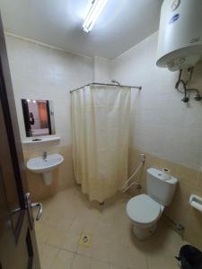 a bathroom with a toilet and a sink and a shower at Alreef Hotel Suits in Muscat