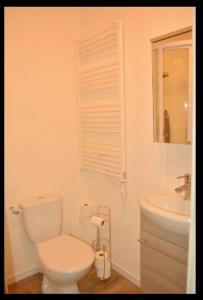 Baño blanco con aseo y lavamanos en L'Atelier de la Blanchardière 49520, en Le Tremblay