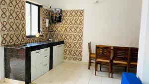 a kitchen with a black counter and a dining room at Highland Beach Apartments Goa in Baga