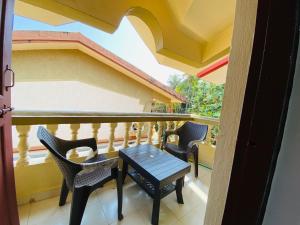 a balcony with chairs and a table on a balcony at Holidays Beach Apartments Goa in Baga