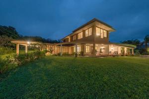 a large house with a large lawn in front of it at SaffronStays Le Farm By The Lake In Kamshet in Somavadi