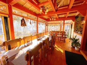 a large dining room with a long table and chairs at Hakuba Pension & Log Hotel Meteor in Hakuba