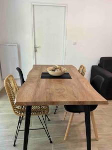 - une table en bois avec un bol de nourriture dans l'établissement Spacieux T3 Métro Saint Cyprien / 4-8 personnes, à Toulouse