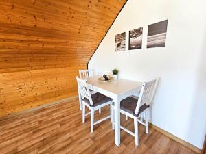 Una mesa y sillas blancas en una habitación con techos de madera. en Cozy Apartment in Klein-Winternheim, en Klein-Winternheim