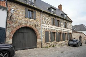 un edificio de ladrillo con garaje y un coche aparcado delante en Le Clos de St Val 4, en Saint-Valery-sur-Somme