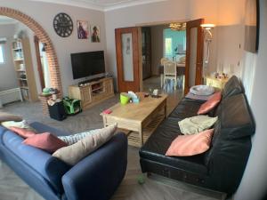 a living room with two couches and a table at Chambre dans habitat partagé chez Séverine in Nivelles