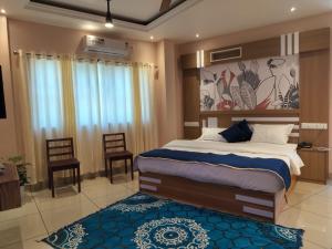 um quarto com uma cama grande e um tapete azul em IvyArk Residency em Pinangode