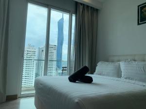 ein Hotelzimmer mit einem Bett und einem großen Fenster in der Unterkunft RS Suites In Bukit Bintang in Kuala Lumpur