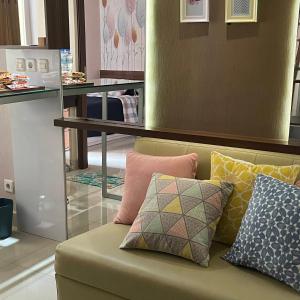 a couch with pillows on it in a store at Cozy 2 BR Sudirman Suites Apartment in Bandung