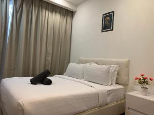ein Schlafzimmer mit einem Bett mit einem schwarzen Teddybär darauf in der Unterkunft RS Suites In Bukit Bintang in Kuala Lumpur