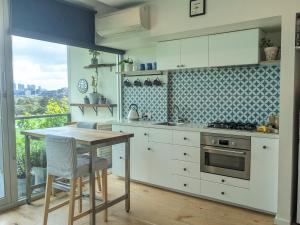 a kitchen with white cabinets and a table and a stove at BestView St Kilda Spectacular Sunset Hideaway - boutique self-contained luxury apartment in Melbourne