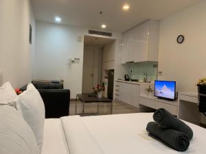 uma sala de estar com um sofá branco e uma cozinha em RS Suites In Bukit Bintang em Kuala Lumpur