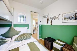ビンツにあるFeWo Prora - Sealion Penthouseの緑と白の壁のベッドルーム1室(ベッド1台付)