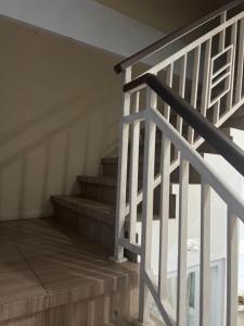 un escalier avec une rampe blanche et une cage d'escalier dans l'établissement Villa Sipaling, à Pesanggaran