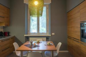 eine Küche mit einem Tisch mit Stühlen und einem Fenster in der Unterkunft Casa Bianca Apartments in Como