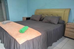 - une chambre avec un lit et une serviette verte dans l'établissement OYO 93071 Home Stay Kembar Syariah, à Binjai