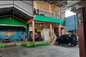 un coche aparcado en un aparcamiento frente a un edificio en OYO 93071 Home Stay Kembar Syariah, en Binjai