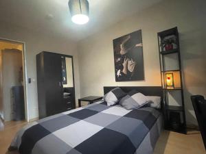 Un dormitorio con una cama con una manta blanca y negra. en Alt Treptow Fashion HQ, en Berlín