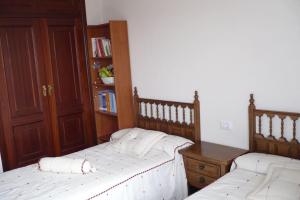 a bedroom with two beds and a book shelf at Piso en Grove in O Grove