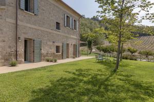 a tree in a yard next to a building at Agriturismo Corbaia Relais in Santa Lucia di Roversano