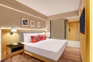 1 dormitorio con 1 cama blanca grande y teléfono en una mesa en Lemon Tree Hotel, Sonamarg en Sonāmarg