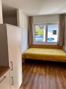 a room with a yellow bench in front of a window at Hotel Lercher in Sankt Veit im Pongau