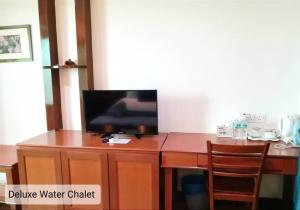 einen TV auf einem hölzernen Schreibtisch in der Unterkunft Alpine LXPD Water Chalet in Port Dickson