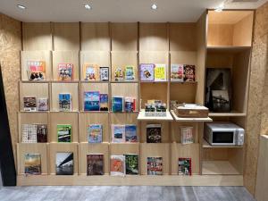 a book shelf filled with lots of books at CHECKinn Osaka Shinimamiya in Osaka