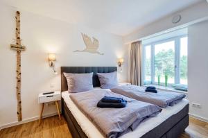 1 dormitorio con 1 cama grande con una cruz en la pared en FeWo Prora - Moin en Binz