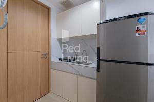 a kitchen with a refrigerator next to a sink at RedLiving Apartemen Jakarta Living Star - BoboRooms in Jakarta
