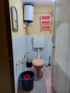 a small bathroom with a toilet and a bucket at Honey Palace Homestay in Madikeri