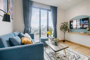 a living room with a blue couch and a table at Crescendo Urban Stay - STAY 24h in Hanoi +97 photos