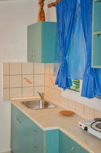 a kitchen with a sink and blue cabinets at Studios Ifigenia in Skala Potamias +53 photos