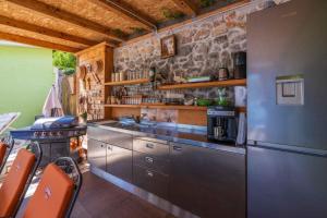 cocina con electrodomésticos de acero inoxidable y pared de piedra en Holiday home in Bribir 34023, en Bribir