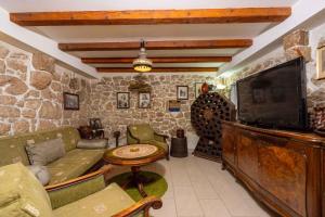 a living room with a tv and a stone wall at Holiday home in Bribir 34023 in Bribir