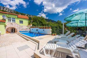 a pool with white lounge chairs and a house at Holiday home in Bribir 34023 in Bribir