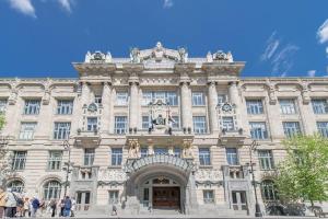 un gran edificio con gente caminando delante de él en Venus Apartments - Skylit - Deluxe Loft with Skylight, en Budapest