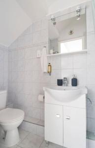 a white bathroom with a toilet and a sink at Venus Apartments - Skylit - Deluxe Loft with Skylight in Budapest +25 photos